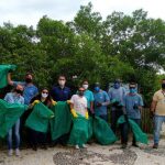 Voluntários fazem coleta de lixo na vegetação da praia de Jurerê Internacional